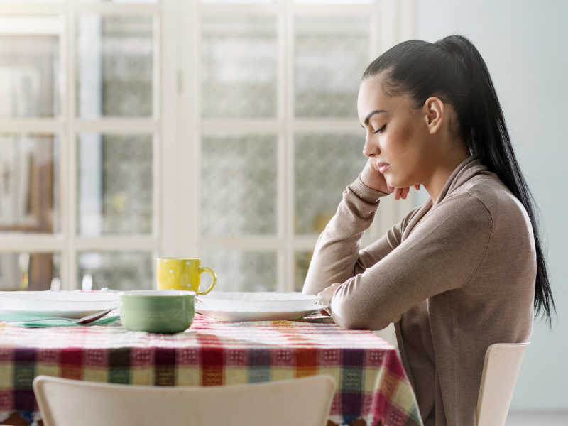 lady alone at a table looking down