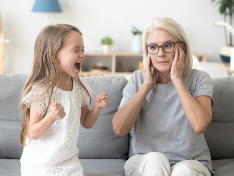 child screaming while mom holds her ears and ignore